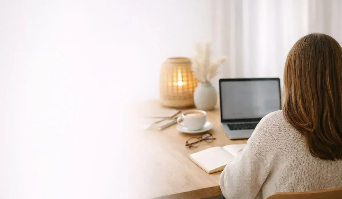 Entrepreneure de dos travaillant sur ordinateur dans un espace calme communication digitale simple Clarté et Com